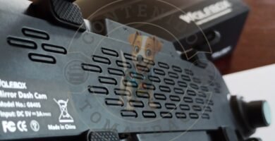 Imagen de la parte trasera de una dashcam Wolfbox modelo G840S, mostrando los detalles de ventilación, sujeción y especificaciones técnicas. En segundo plano se aprecia la caja original del producto. Marca de agua visible de Tomaydaca.