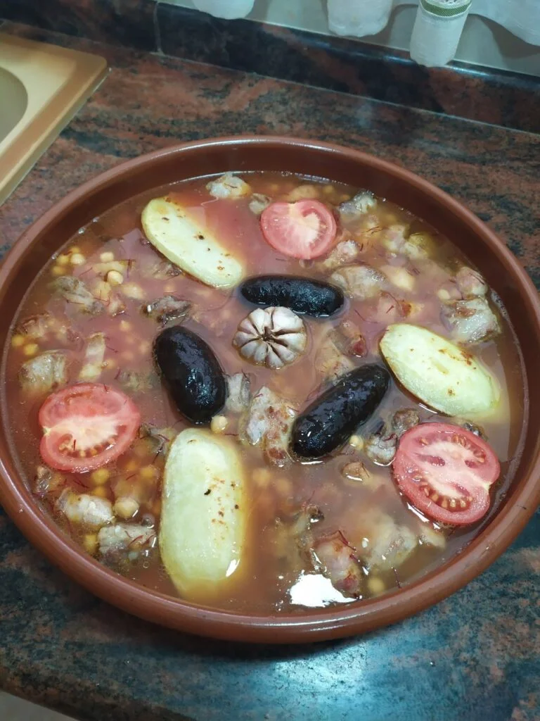 Cazuela de barro con arroz, cabeza de ajos, panceta, costilla de cerdo, garbanzos, caldo y morcillas (arroz al horno)